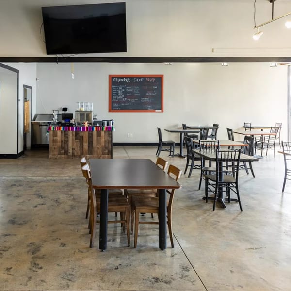 Interior of Chonchis Taco Shop with tables, chairs, a counter, and a menu board.
